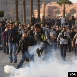 Demonstran anti Mubarak menendang gas air mata yang dilemparkan tentara Mesir untuk melerai bentrokan di Kairo, (3/2).