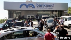 افسران پلیس و ارتش لبنان در بیرون از بانکی در جنوب لبنان که به اشغال سپرده‌گذاران در‌آمده، تجمع کرده‌اند - ۱۶ سپتامبر ۲۰۲۲ (۲۵ شهریور ۱۴۰۱) 