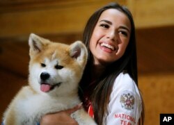 Russian Women's Olympic figure skating gold medalist Alina Zagitova holds an Akita puppy named Masaru presented by Japanese Prime Minister Shinzo Abe, in Moscow, Russia, May 26, 2018. Abe is in Russia for talks with President Vladimir Putin in hopes of making progress on joint economic projects on disputed islands as a step toward resolving a decades-old territorial row.