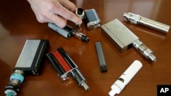 This April 10, 2018 photo shows vaping devices taken from students at Marshfield High School in Marshfield, Mass. (AP Photo/Steven Senne)