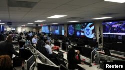 FILE - U.S. Department of Homeland Security election security workers monitor screens in the DHS National Cybersecurity and Communications Integration Center in Arlington, Va., Nov. 6, 2018. 