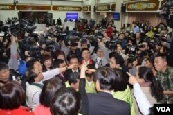 2014年 3月12日 ，台湾立法院有关服贸协议审议还没开始，就围绕程序问题相互呛声，会场混乱。民进党立委占领主席台，国民党立委抗议 。（美国之音申华拍摄）