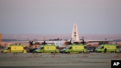 Ambulan berbaris saat para pekerja darurat menurunkan mayat-mayat korban kecelakaan pesawat Rusia di Semenanjung Sinai, di bandara militer Kabrit, sekitar 32 kilometer sebelah urata Suez, Mesir (31/10). (AP/Amr Nabil)