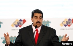 FILE - Venezuela's re-elected President Nicolas Maduro gestures after he received a certificate given by the National Electoral Council (CNE), confirming him as winner, in Caracas, Venezuela, May 22, 2018.