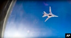 FILE - In this frame grab from video provided by Russian Defence Ministry press service, a Russian long-range bomber Tu-22M3 flies during an airstrike over the Aleppo region of Syria, Aug. 16, 2016.