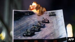 在香港维多利亚公园参加纪念六四事件31周年的一名男子手持天安门广场“坦克人”的照片。（法新社2020年6月4日）