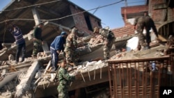 Des militaires indiens et des habitants du lieu fouillent dans les décombres laissées par un séisme de magnitude 6,7 qui a touché le nord-est de l'Inde, 4 janvier 2015.