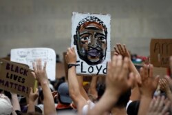 People hold up a likeness of George Floyd at a public memorial after his death in Minneapolis police custody, in the Brooklyn borough of New York City, New York, June 4, 2020.