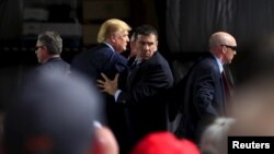 Secret Service agents surround U.S. Republican presidential candidate Donald Trump during a disturbance as he speaks at Dayton International Airport in Dayton, Ohio, March 12, 2016. (REUTERS/Aaron P. Bernstein)