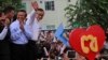 Opposition Cambodia National Rescue Party (CNRP) leader Sam Rainsy, right, accompanied by his party's Vice President Kem Sokha, second from right, waves to his party supporters during a public forum of the July 28 election result, in Phnom Penh, Cambodia, Monday, Aug. 26, 2013.