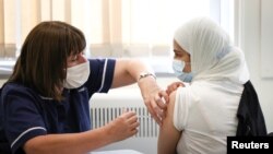 Seorang warga sedang divaksin COVID-19 di pusat vaksinasi di Belmont Health Centre di Harrow, London, Inggris, 6 Juni 2021. (Foto: Henry Nicholls/Reuters)