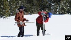 Frank Gehrke, chief of the California Cooperative Snow Surveys Program, for the Department of Water Resources, right, plunges the snow survey tube into the snow to check the depth of the snowpack during a supplemental snow survey, March 5, 2018, near Echo Summit, California.