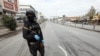FILE - A security man stands in an empty street during a curfew imposed by Iraqi Kurdish authorities, following the outbreak of coronavirus, in Sulaimaniya, in Iraqi Kurdistan, lraq, March 14. 2020. 