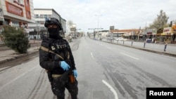FILE - A security man stands in an empty street during a curfew imposed by Iraqi Kurdish authorities, following the outbreak of coronavirus, in Sulaimaniya, in Iraqi Kurdistan, lraq, March 14. 2020. 