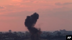FILE - Smoke rises after an Israeli missile strike in the Gaza strip as seen from the Israel Gaza border, July 16, 2014. 