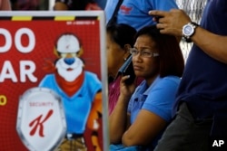 Workers wait for information about their jobs outside the Kellogg's factory in Maracay, Venezuela, May 15, 2018.