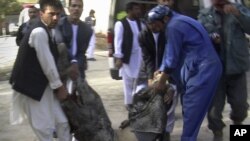 Afghans carry the body of a suicide attack victim at the hospital in Maymana, Faryab province northwest of Kabul, Afghanistan, October 26, 2012.