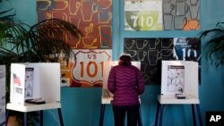 FILE - A woman votes at a polling station inside a coffee shop in Los Angeles, March 7, 2017. The California secretary of state was among those who rejected a request for voter information from President Donald Trump's commission investigating alleged voter fraud.
