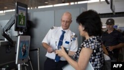 Une femme embarquant sur un vol SAS à destination de Copenhague passe le système de vérification de la reconnaissance faciale VeriScan à l'aéroport international Dulles de Dulles, en Virginie, le 6 septembre 2018