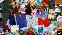 Dolls and teddy bears are placed at a memorial in a gazebo on the Promenade des Anglais in Nice, southern France on July 20, 2016.