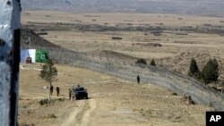 FILE - Pakistani soldiers stand guard at a newly erected fence between Pakistan and Afghanistan at Angore Adda, Pakistan, Oct. 18, 2017. 