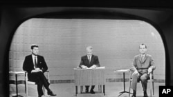 In this Sept. 26, 1960 file photo, moderator Howard K. Smith sits between, Sen. John Kennedy, left, and Vice President Richard Nixon as they appear on television studio monitor set during their debate in Chicago.