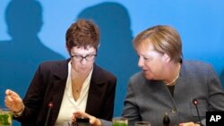 German Chancellor and chairwoman of the German Christian Democratic Union (CDU), Angela Merkel, right, and Annegret Kramp-Karrenbauer, left, Secretary General of the CDU, talk as they arrive for a closed-door meeting in Berlin, Germany, Sunday, Nov. 4, 2018.