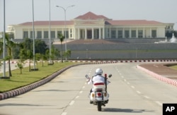 A police motorcycle approaches the President's Office in Naypyidaw, Myanmar, Dec. 1, 2011.