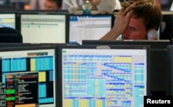 Traders from BGC, a global brokerage company in London's Canary Wharf financial centre react as European stock markets open early June 24, 2016 after Britain voted to leave the European Union