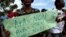 FILE - A protester holds a sign that reads in French "A+A=No. A+B=Yes. B+B=No" during an anti-gay demonstration in Port-au-Prince, Haiti.