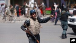 An Afghan policeman stands guard after an explosion near the police headquarters in Kabul, Afghanistan, Aug. 7, 2019. 