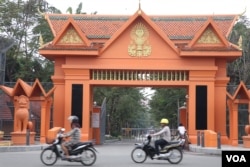 អ្នក​ធ្វើ​ដំណើរតាម​បណ្តោយ​ផ្លូវ​ព្រះនរោត្តម ជិះកាត់​ស្ថាប័ន​ព្រឹទ្ធសភា ដែល​មាន​ទីតាំង​ជាប់​នឹង​ទីស្នាក់ការកណ្តាល​របស់​គណបក្ស​ប្រជាជន​កម្ពុជា​ក្នុង​ខណ្ឌ​ចំការ​មន។ (ស៊ុន ណារិន/VOA)