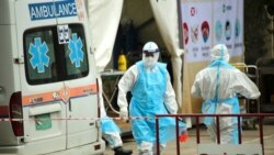 រូបឯកសារ៖ ក្រុមមន្ត្រីសុខាភិបាលស្ថិតក្នុងឯកសណ្ឋានការពារពីការឆ្លងជំងឺកូវីដ១៩ បញ្ជូនអ្នកជំងឺកូវីដ១៩ មកទទួលការព្យាបាលនៅមណ្ឌលព្យាបាល នៅកោះពេជ្រ រាជធានីភ្នំពេញ ថ្ងៃទី១៥ ខែមេសា ឆ្នាំ២០២១។ (ហ៊ាន សុជាតា/វីអូអេ)