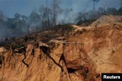 A wildcat gold miner uses high-pressure jets of water to dislodge rock material at a mine, also known as garimpo, at a deforested area of Amazon rainforest near Crepurizao, Brazil, Aug. 2, 2017.