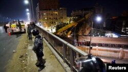 Des soldats montent la garde sur un pont au-dessus de la scène d'un accident de train dans la ville de Qalyub, au nord du Caire, en Égypte, le 7 mars 2023.