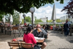 A guest enjoys his beer at a beer garden near the Chancellery in Berlin, Germany, May 21, 2021, as parts of the country began easing COVID-19 restrictions.