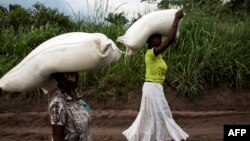 Des femmes congolaises portent des sacs de nourriture sur leurs têtes lors d'une distribution de nourriture à Kasala, dans la région agitée du Kasaï, RDC, 25 octobre 2017. 