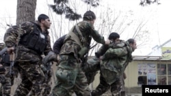 4일 아프가니스탄 북부 마자리샤리프 주재 인도 영사관 주변에서 보안군과 무장괴한들 사이에 총격전이 벌어진 가운데, 보안군이 부상당한 동료를 부축하고 있다.