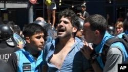 Police detain a protester during an anti-government demonstration against the economic reforms of President Javier Milei in Buenos Aires, Argentina, Dec. 27, 2023.
