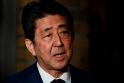 Japan's Prime Minister Shinzo Abe talks to journalists in Tokyo, March 24, 2020.