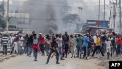 Kenyan opposition supporters react and throw stones towards Kenya Police officers during demonstrations in Nairobi, Kenya on July 12, 2023.