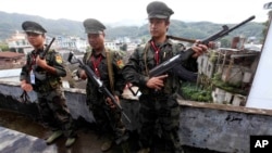 FILE - In this Oct. 29, 2013, file photo, soldiers of the Kachin Independence Army stand on guard in Laiza, a border town of China and Myanmar, Kachin State, Myanmar. 
