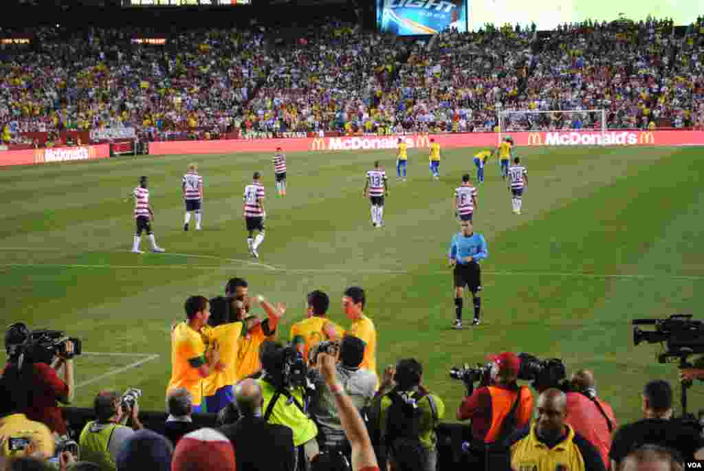 Brazilian players gather around Marcelo (no. 6) after he scores Brazil&#39;s third goal, making the score 3-1. VOA/M. Lipin