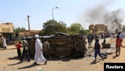 A police car flipped over and damaged by mourners near the home of a demonstrator who died of a gunshot wound sustained during anti-government protests in Khartoum, Sudan, Jan. 18, 2019.