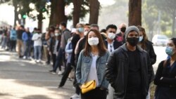 FILE - People queue to receive a vaccination at the NSW Vaccine Centre at Homebush Olympic Park in Sydney, Australia, July 1, 2021.