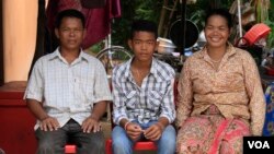 Chheum Sokhoch, middle, is pictured with his father Plung Bunkhiem, 40, and his mother, Voeun Ya, 36, at their home in Krobey Riel commune, Siem Reap, Cambodia, July 13, 2017. (Sun Narin/VOA Khmer)