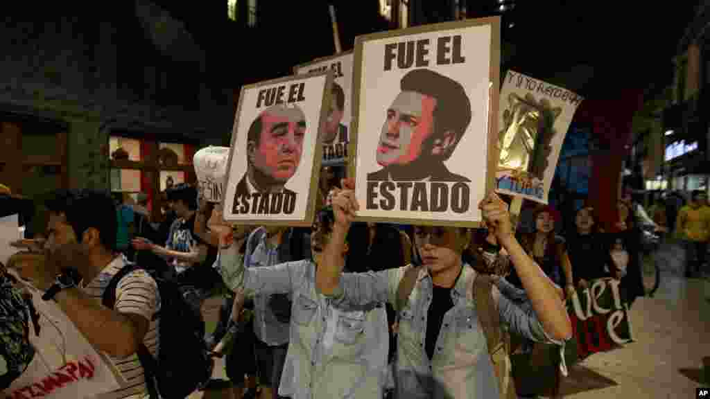 Para demonstran memegang poster-poster Presiden Meksiko&nbsp;Enrique Pena Nieto (kanan) dan Jaksa Agung&nbsp;Jesus Murillo Karam (kiri) dalam protes atas hilangnya 43 mahasiswa di negara bagian Guerrero, di Mexico City (5/11).&nbsp;(AP/Eduardo Verdugo) 