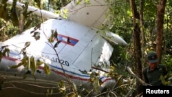 A rescue worker makes his way past the wreckage of an air force plane at its crash site near Nadee village, in Xiang Khouang province in the north of the country, May 17, 2014. 