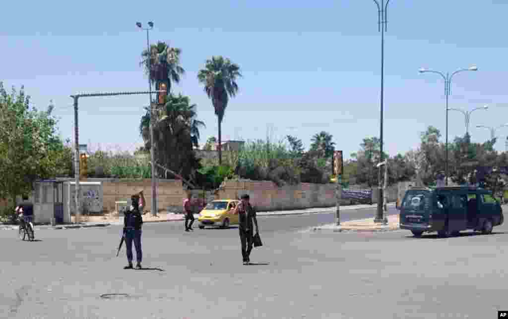 &quot;Iroq va Shom islomiy davlati&quot; guruhi jangarisi ko&#39;chada mashinalar harakatini tartibga solmoqda, Mosul, Iroq, 22-iyun, 2014-yil. &nbsp;