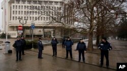 Petugas Kepolisian Ukarina berjaga di depan gedung kantor pemerintah daerah di Simferopol, Krimea, Ukraina (27/2). 